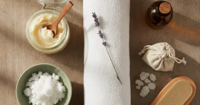 Flat lay : beurre de karité, huile de coco, sel marin et pierre ponce pour le soin des crevasses des pieds