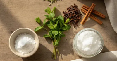 Ingrédients naturels contre la mauvaise haleine : menthe, clous de girofle, bicarbonate et huile de coco sur plan en bois