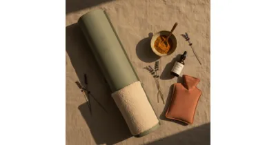 Nerf sciatique remèdes naturels : tapis de yoga, huile de ricin, curcuma et bouillotte en flat lay
