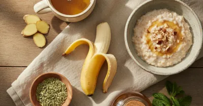 Flat lay : tisane de camomille, gingembre frais, graines de fenouil, banane, miel et feuilles de menthe sur nappe en lin beige pour soulager le reflux gastro-oesophagien