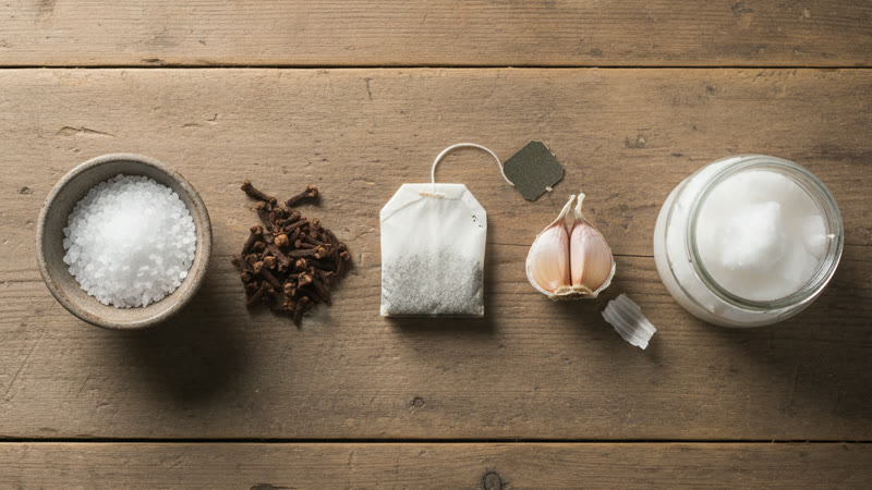 Les ingrédients naturels contre l'abcès dentaire : sel de mer, clous de girofle, sachet de thé noir, ail et huile de coco